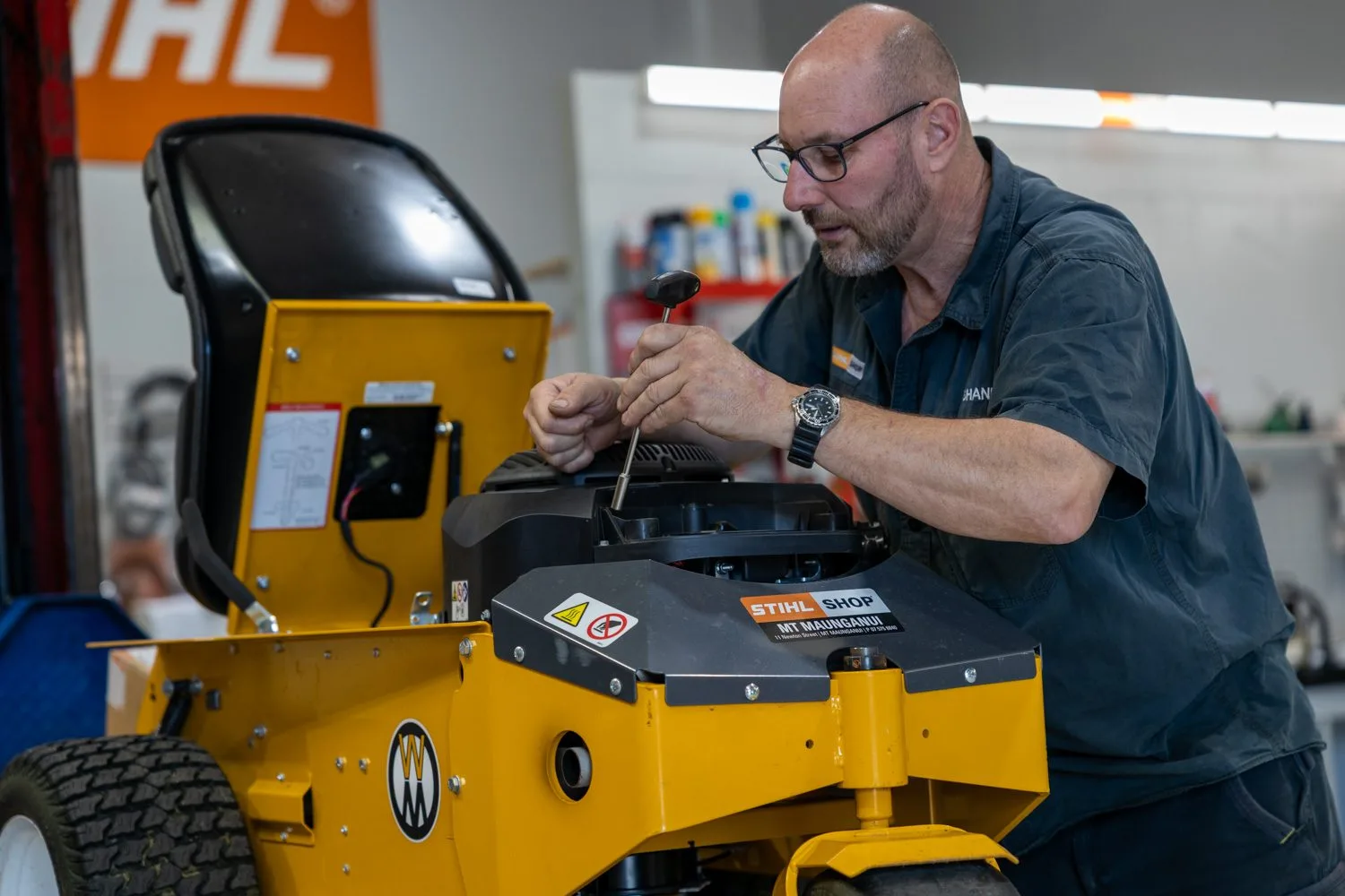 A technician servicing a Cub Cadet ride-on mower in the workshop